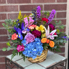 Colorful mixed flower arrangement in a woven basket