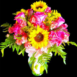 Bouquet of pink roses and yellow sunflowers in a glass vase