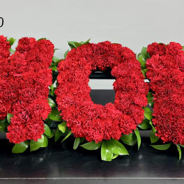 Red carnation letters spelling MOM with green leaves