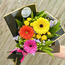 Bouquet of colorful gerbera daisies wrapped in black paper