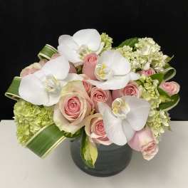 Pink roses and white orchids in a dark vase