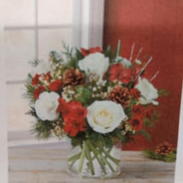 Red and white flower arrangement in a clear glass vase
