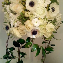 White bridal bouquet with roses and anemones, trailing greenery