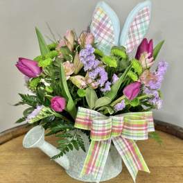 Tulip bouquet in a watering can with plaid bunny ears and ribbon