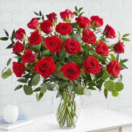 Red roses arranged in a clear glass vase