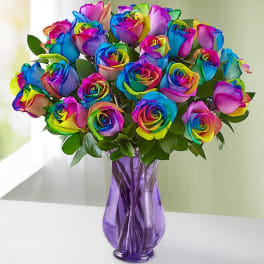Bouquet of rainbow-colored roses in a purple glass vase