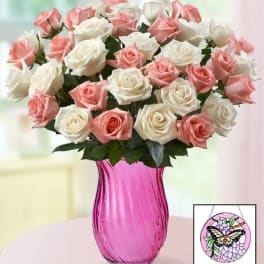 Pink and white roses arranged in a bright pink vase