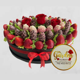 Chocolate-covered strawberries and red roses in a round gift box