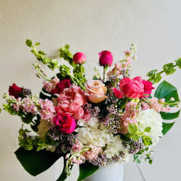 Mixed pink and white flower arrangement in a white vase