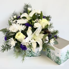 White lilies and roses in a decorative tin container