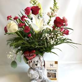 Bouquet with red and white flowers in a teddy bear gift arrangement