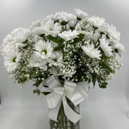 White daisy bouquet in a glass vase with a white ribbon