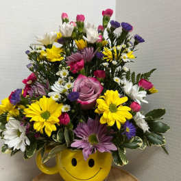 Mixed bouquet in a yellow smiley-face mug vase