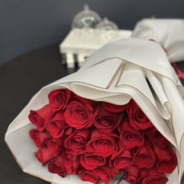 Bouquet of red roses wrapped in white paper
