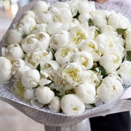 Large bouquet of white peonies wrapped in patterned paper