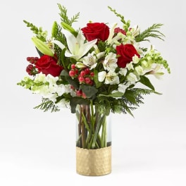 Red roses and white lilies in a glass vase with gold wrap