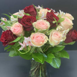 Bouquet of red and blush roses in a glass vase