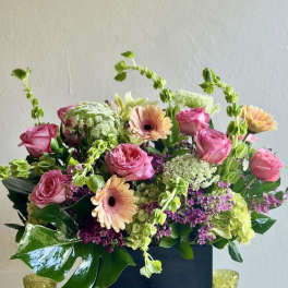 Pink roses and peach gerbera daisies in a black box arrangement