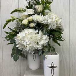 White floral arrangement in two white vases with cross accents