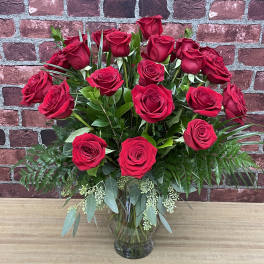 Red roses arranged in a clear glass vase
