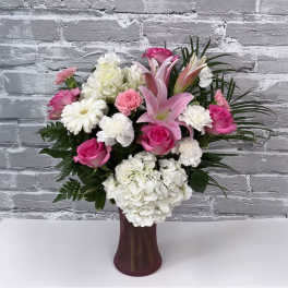 Pink and white flower arrangement in a dark vase
