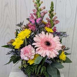Mixed flower basket with pink gerbera, yellow mums, and snapdragons