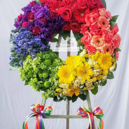 Rainbow floral wreath on an easel with ribbon bows