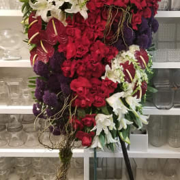 Large cascading bouquet of red and white flowers with purple accents
