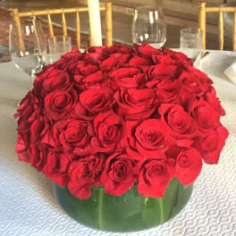 Large bouquet of red roses in a green vase on a table