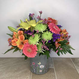 Colorful mixed bouquet in a floral tin container