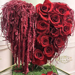 Red roses arranged in a heart shape with burgundy hanging accents