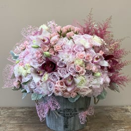 Pink and lavender floral arrangement in a metal bucket