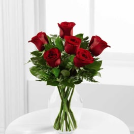 Red roses arranged in a clear glass vase
