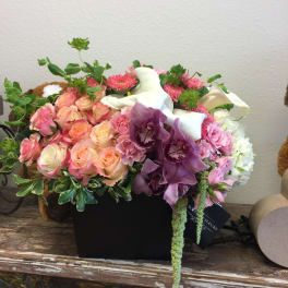 Mixed bouquet of pink roses, purple orchids, and white calla lilies in a black box