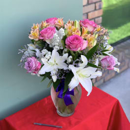 Bouquet of pink roses and white lilies in a glass vase