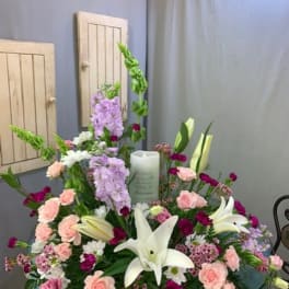 Large floral sympathy arrangement with white lilies, pink roses, and lavender blooms