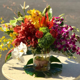 Colorful tropical flower arrangement in a clear glass vase
