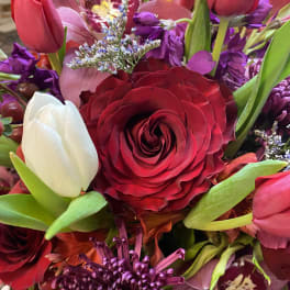 Mixed bouquet with red and white tulips, a red rose, and purple flowers