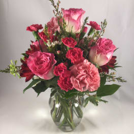 Pink roses and carnations in a clear glass vase