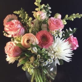 Mixed bouquet of pink and white flowers in a clear glass vase