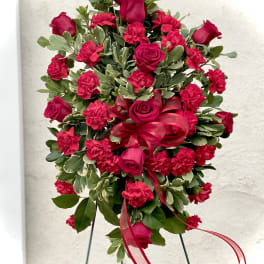 Standing floral spray with red roses and carnations on an easel