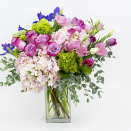 Bouquet of pink and purple flowers in a clear glass vase