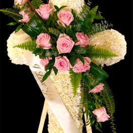 Pink roses and white flowers arranged on a standing easel with a sash