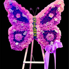 Butterfly-shaped floral display in pink and purple on an easel