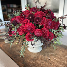 Red floral arrangement in a white vase