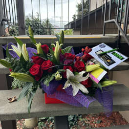 Bouquet of red roses and white lilies with purple wrap