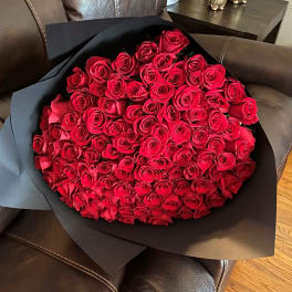 Large bouquet of red roses wrapped in black paper