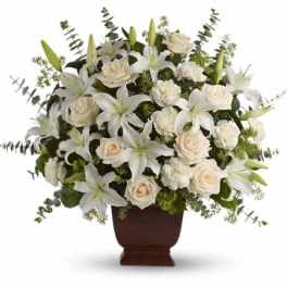 White lilies and cream roses arranged in a brown vase
