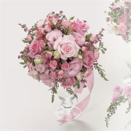 Pink rose bouquet in a clear glass vase with a ribbon