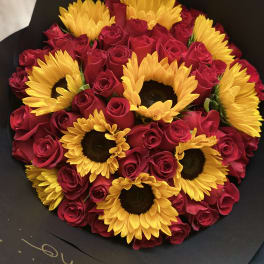 Bouquet of red roses and yellow sunflowers wrapped in black paper